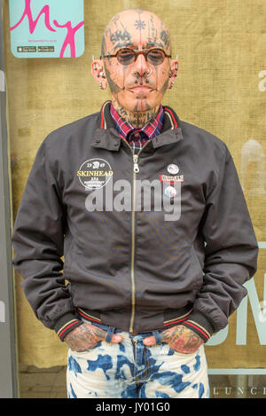 Ältere französische Punk, mit Gesichts Piercings und Tattoos Posieren für ein Porträt außerhalb ein Geschäft im Stadtzentrum von Canterbury, Kent. Stockfoto