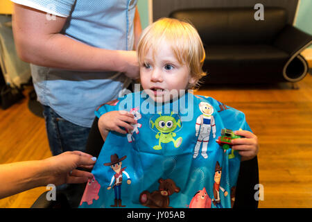 Kaukasische Toddler boy sitzt und weint, während Er sich die Haare schneiden. Stockfoto