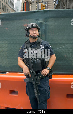 Eine bewaffnete asiatischen amerikanischen Anti-Terror-Polizisten auf Streife in Times Square, Manhattan, New York City Stockfoto