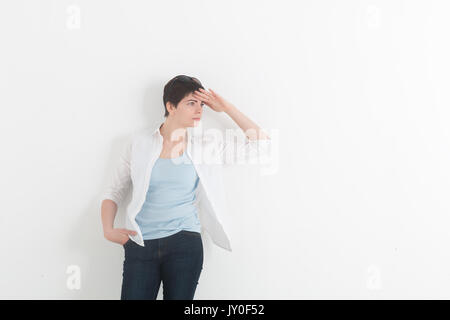 Junge Frau im weißen Hemd seine Hand über die Augen. Vorsichtig sein. Schöne Mädchen auf einem weißen Hintergrund. Platz für Text. Stockfoto