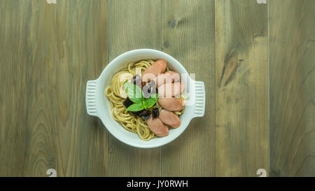 Spaghetti mit Wurst und getrocknete Paprika, würzig und scharf auf hölzernen Hintergrund, Ansicht von oben Stockfoto