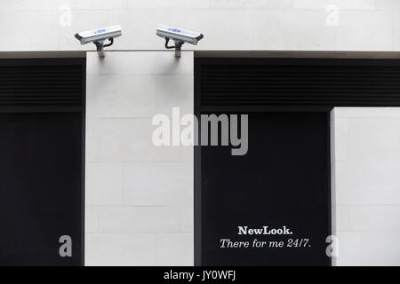 Londoners Spaziergang unter zwei CCTV-Kameras in der Stadt London, einer der meistgesehenen am 11 August, 2017 in London, England. Nach 2011 gibt es 420.000 CCTV-Kameras in London. Stockfoto