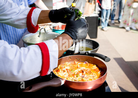 Muscheln und Fische, die von den Küchenchef auf einem metallauflagefach in der Firma wein Sauce, Kräuter und Gewürzen zubereitet Stockfoto