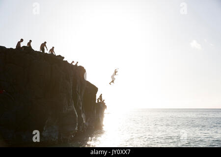 Freunde Springen von der Klippe ins Meer Stockfoto