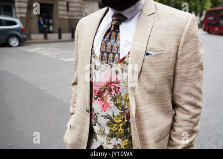 Nahaufnahme von einem Mann mit beige Jacke, Weste und Krawatte Blumenmuster Stockfoto