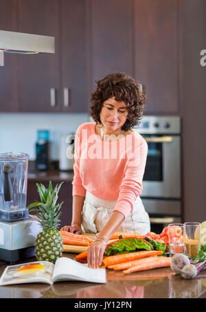 Hispanic Frau lesen Kochbuch Stockfoto