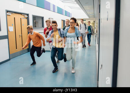 Jugendlich Studenten laufen über den Flur der Schule, in einem Rush für die Sommerferien zu verlassen. Stockfoto