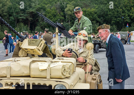 Ältere Kriegsveteranen im Gespräch mit jungen WK 2 reenactors in WWII Jeep mit montierten maschinengewehr Vickers K während des Zweiten Weltkriegs militaria Messe Stockfoto