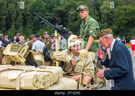 Ältere Kriegsveteranen im Gespräch mit jungen WW2 reenactor in WWII Jeep mit montierten maschinengewehr Vickers K während des Zweiten Weltkriegs militaria Messe Stockfoto