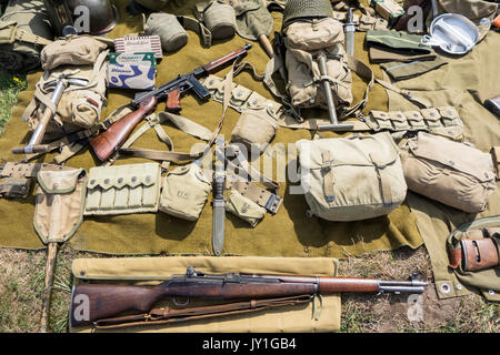 WW2 US-Soldat Outfit und Waffen auf dem Boden im Zweiten Weltkrieg militaria Messe zeigen M1 Garand Gewehr und Thompson Maschinenpistole angezeigt Stockfoto