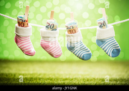 Zwei Paar Baby Socken mit Dollar hängen am Seil mit hölzernen Clip Stockfoto