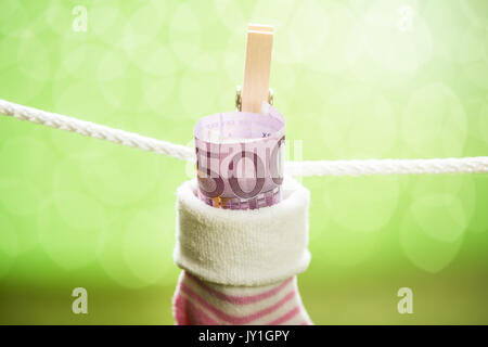 Baby Socken mit Dollar hängen am Seil mit hölzernen Clip Stockfoto