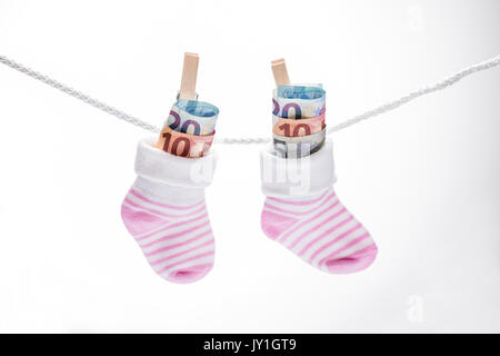 Paar Baby Socken mit Dollar hängen am Seil mit hölzernen Clip Stockfoto