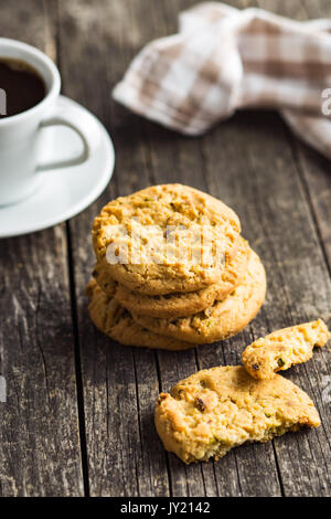 Süße Pistazien Plätzchen und Kaffee Tasse auf alten Holztisch. Stockfoto