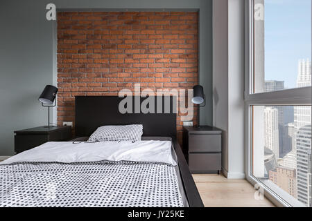 Einfache Schlafzimmer mit Doppelbett, Mauer und große Fenster Stockfoto