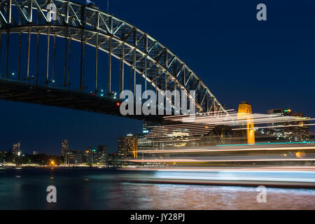 Kreuzfahrtschiff mit Sydney Harbour Bridge bei Nacht. Sydney, New South Wales, Australien Stockfoto