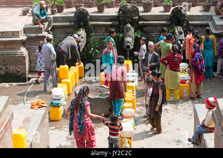 Kathmandu, Nepal - 9. März 2013: Menschen, die darauf warten, bis sie an der Reihe sind sauberes Wasser in der Öffentlichkeit zu sammeln in Katmandu Stadt tippen. Stockfoto