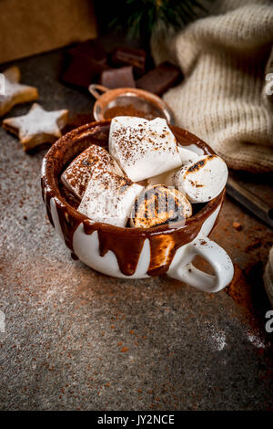 Neues Jahr und Weihnachten behandelt. Traditionelle Spezialitäten. Eine Tasse heiße Schokolade mit Marshmallows gebraten auf Feuer, Lebkuchen Sterne, mit dem Pullover auf Schwarz sto Stockfoto