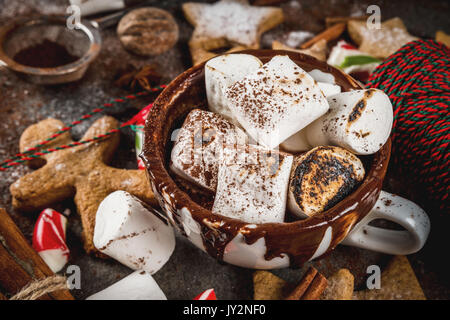 Neues Jahr, weihnachtliche Leckereien und Süßigkeiten. Tasse heiße Schokolade mit gebratenen Marshmallow, Ingwer* Kekse, Lebkuchen Männer, gestreifte Candy, Gewürze Zimt Stockfoto