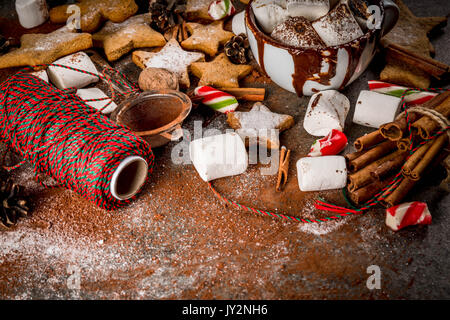 Neues Jahr, weihnachtliche Leckereien und Süßigkeiten. Tasse heiße Schokolade mit gebratenen Marshmallow, Ingwer* Kekse, Lebkuchen Männer, gestreifte Candy, Gewürze Zimt Stockfoto