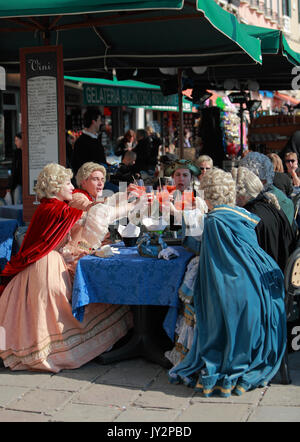 Venedig, Italien, 26. Februar 2011: Eine Gruppe von Menschen tragen traditionelle mittelalterliche Venezianischen Kostümen feiern auf einer Terrasse an der Straße in Venedig während der Stockfoto