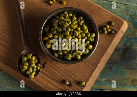 Raw Green Organic marinierte Kapern in eine Schüssel geben. Stockfoto