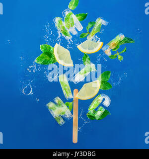 Ice Cube Schriftzug mit gefrorenen Minze, Zitronenscheiben und Orangen auf einem blauen Hintergrund mit Wasser spritzt. Text sagt Aloha Stockfoto