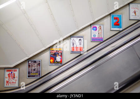 Die Werbeflächen auf der Wand der Fahrtreppe in einem Londoner U-Bahnhof. Stockfoto