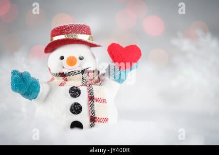 Ein Schneemann und mini Herz Kissen auf bokeh Hintergrund, mit Kopie Raum für Saison Gruß. Frohe Weihnachten und ein glückliches Neues Jahr, AF, Klasse Stockfoto