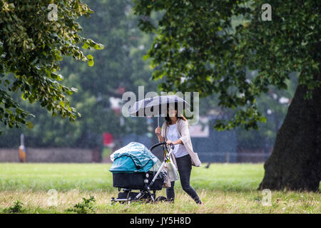 London, Großbritannien. 18. August 2017. Ein starker Regenguss Fänge Leute auf Clapham Common aber bald vorbei und die Sonne zurück. London 18. Aug 2017. Credit: Guy Bell/Alamy leben Nachrichten Stockfoto