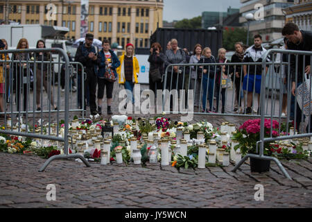 Turku, Finnland. 19. August 2017. Menschen, Kerzen und Blumen am Tatort Messerangriff in Turku Marktplatz. Zwei Menschen getötet und sechs weitere in einem Messer angriff, der am Freitag, den 18. August fand in Turku Marktplatz und Puutori verwundet. Die Polizei war in der Lage, die Angreifer innerhalb von Minuten nach dem ersten Notruf von ihm Schießen auf den Oberschenkel. Die Polizei ermittelt gegen den Angriff als ein Akt des Terrorismus. Credit: Jarmo Piironen/Alamy leben Nachrichten Stockfoto