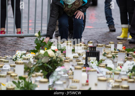 Turku, Finnland. 19. August 2017. Menschen, Kerzen und Blumen am Tatort Messerangriff in Turku Marktplatz. Zwei Menschen getötet und sechs weitere in einem Messer angriff, der am Freitag, den 18. August fand in Turku Marktplatz und Puutori verwundet. Die Polizei war in der Lage, die Angreifer innerhalb von Minuten nach dem ersten Notruf von ihm Schießen auf den Oberschenkel. Die Polizei ermittelt gegen den Angriff als ein Akt des Terrorismus. Credit: Jarmo Piironen/Alamy leben Nachrichten Stockfoto