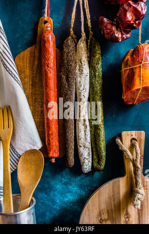 Sortiment von traditionellen spanischen Wurstwaren Wurstwaren, Küchengeräte, Handtuch, Holz Schneidebrett, rustikales Interieur Stockfoto