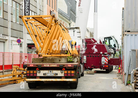 Kristiansand, Norwegen - 1 August 2017: Dokumentarfilm über den Alltag in der Stadt. Bauarbeiter sicherung Kran Teile auf Lkw für den Transport. Mobi Stockfoto