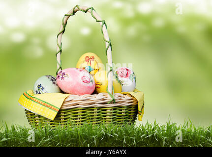 Korb mit Ostereiern auf grünem Hintergrund. Stockfoto