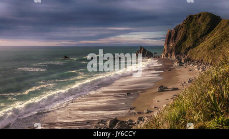 Ocean Surf auf wilden menschenleeren Strand auf der Südinsel Neuseelands Westküste, Erstellen von Schaum und Rückspülung. Stockfoto