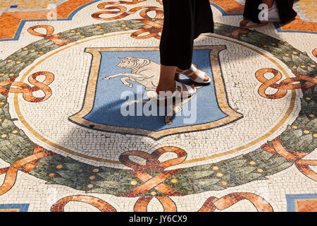 Das Glück, das Ritual des Drehens auf die Kugeln der Stier in der Galleria Vittorio Emanuele II in Mailand, Italien. Stockfoto