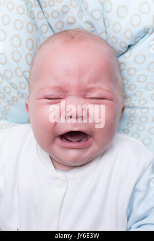 Porträt einer niedlichen Baby Junge sitzt und weint. Adorable 7 Monate alten Kind. Stockfoto