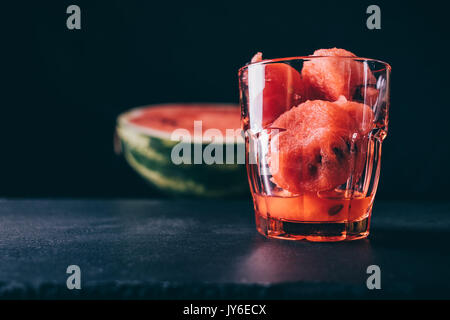 Glas mit in Scheiben geschnittenen Wassermelone auf schwarzem Hintergrund close-up Stockfoto