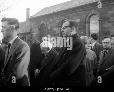 Harold Hardman (Mitte), Vorsitzender von Manchester United, beugt seinen Kopf, als, mit England Team Manager Walter Winterbottom (r), betrauert er bei der Beerdigung von Manchester United Kapitän Roger Byrne auf Flixton Pfarrkirche, in der Nähe von Manchester. Byrne war einer der Spieler in der Münchner getötet. Stockfoto