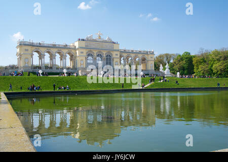 Wien, ÖSTERREICH - Apr 29th, 2017: Der Gloriette beherbergt ein Café und eine Aussichtsplattform mit Panoramablick auf das Schloss Schönbrunn und seine Gärten, klarer Himmel mit einigen Wolken und Reflexion im Wasser Stockfoto