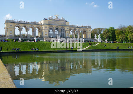 Wien, ÖSTERREICH - Apr 29th, 2017: Der Gloriette beherbergt ein Café und eine Aussichtsplattform mit Panoramablick auf das Schloss Schönbrunn und seine Gärten, klarer Himmel mit einigen Wolken und Reflexion im Wasser Stockfoto