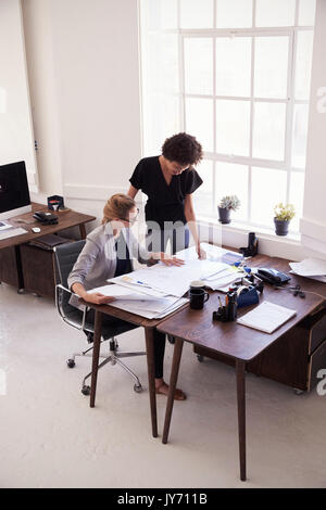 Zwei Geschäftsfrauen Studium Dokumente in einem Büro, vertikal Stockfoto