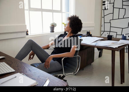 Junge Geschäftsfrau sitzt in einem Büro Stockfoto