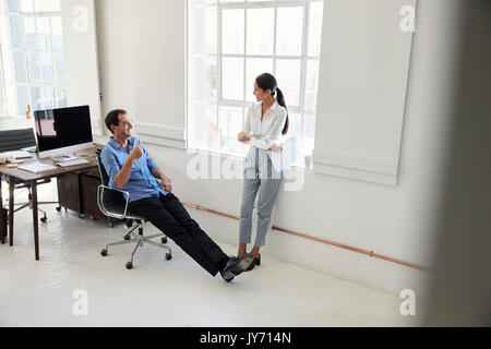 Eine männliche und eine weibliche business Kollegen sprechen in einem Büro Stockfoto