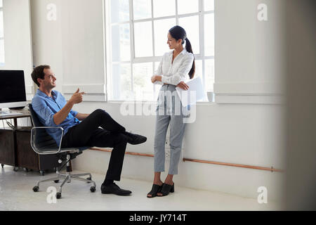 Zwei Kollegen plaudern in einem Büro Stockfoto