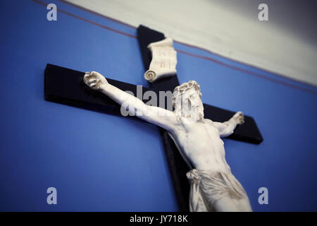 Hölzerne Kreuz mit Jesus auf einer blauen Wand Stockfoto