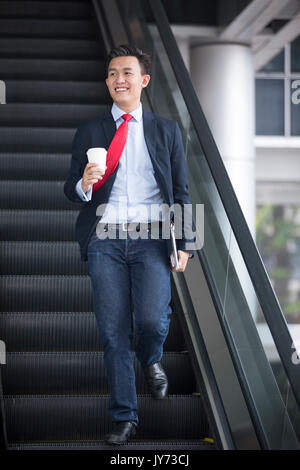 Chinesische Geschäft Mann in modernen asiatischen Stadt. Porträt eines asiatischen Geschäftsmann lächelnd und mit Blick auf die Kamera mit unscharfen Bürogebäude als backgro Stockfoto