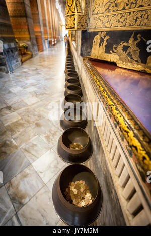 Goldmünzen in Bronze Schalen als Angebot an der liegende Buddha, Wat Pho Tempel, Bangkok, Thailand gegeben Stockfoto