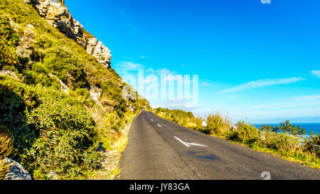 Die Straße zum Chapman's Peak entlang der atlantischen Küste am Slangkop Lighthouse in der Nähe des Dorfes Het Kommetjie in der Kap Halbinsel von Südafrika Stockfoto